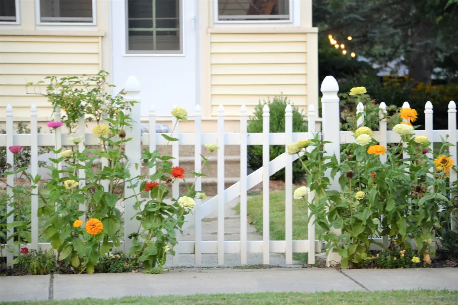 An exterior of the front house with white picketed fence.